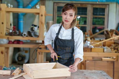 Portrait of beautiful asian woman carpenter dealing with handicraft