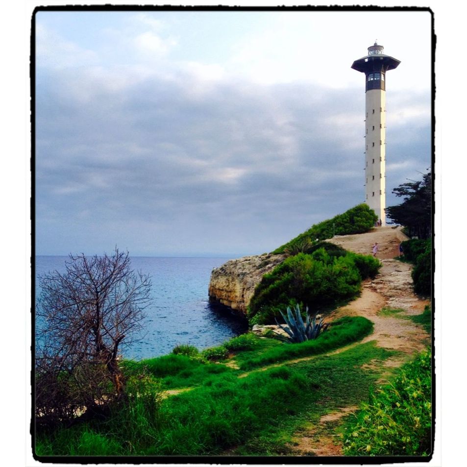 sky, sea, transfer print, horizon over water, water, cloud - sky, auto post production filter, scenics, tranquility, tranquil scene, beauty in nature, lighthouse, nature, cloudy, rock - object, cloud, grass, idyllic, built structure, tree