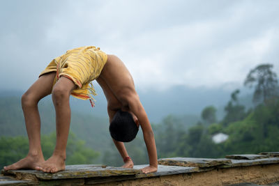 Low section of man climbing on rock