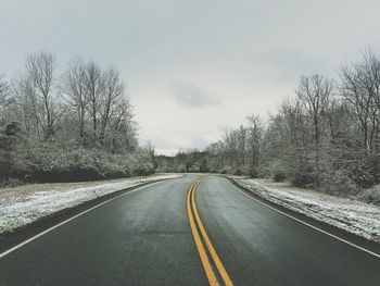 Road amidst trees against sky