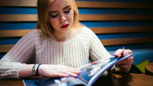 Close-up of young woman reading book