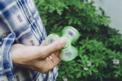 Midsection of man spinning fidget spinner