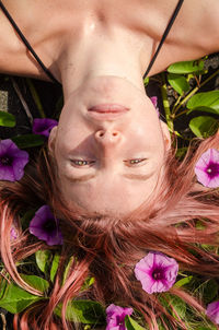 Directly above shot of woman lying on field with flowers