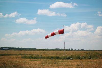 Red flag on field against sky