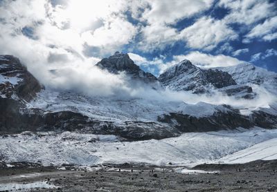 Scenic view of snowcapped mountains against cloudy sky