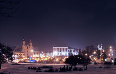 Illuminated city against clear sky at night