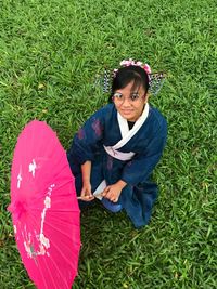 Portrait of smiling young woman sitting on grass