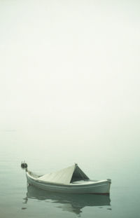 Boat moored in lake against sky