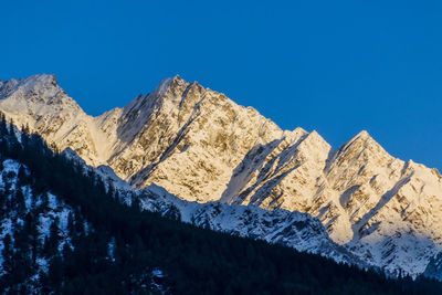 Scenic view of snowcapped mountains against clear blue sky