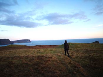 Rear view of man walking on field