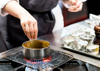 Midsection of man preparing food in kitchen