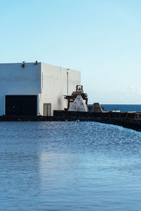 Man by sea against clear sky