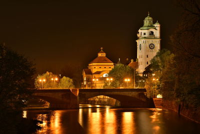 Illuminated buildings against sky at night