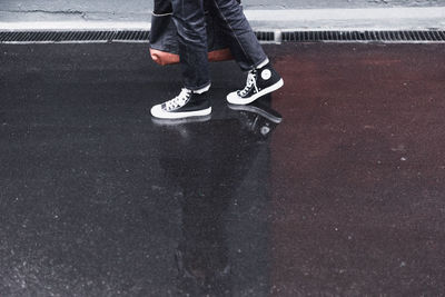 Low section of man walking on road