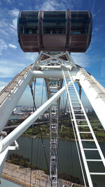 Ferris wheel against sky in city on sunny day