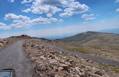 Road leading towards mountains against sky