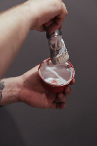 Cropped hand of man holding shaving cream