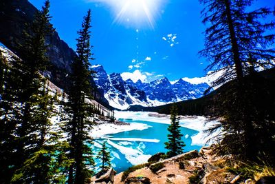Scenic view of snowcapped mountains against bright sun