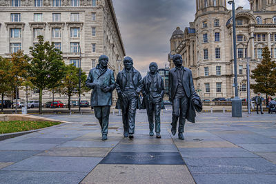 Bronze statue of the beatles at pier head in liverpool