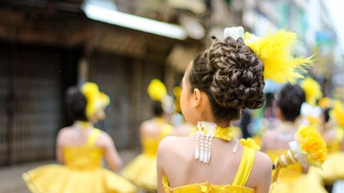 Rear view of woman with yellow flowers