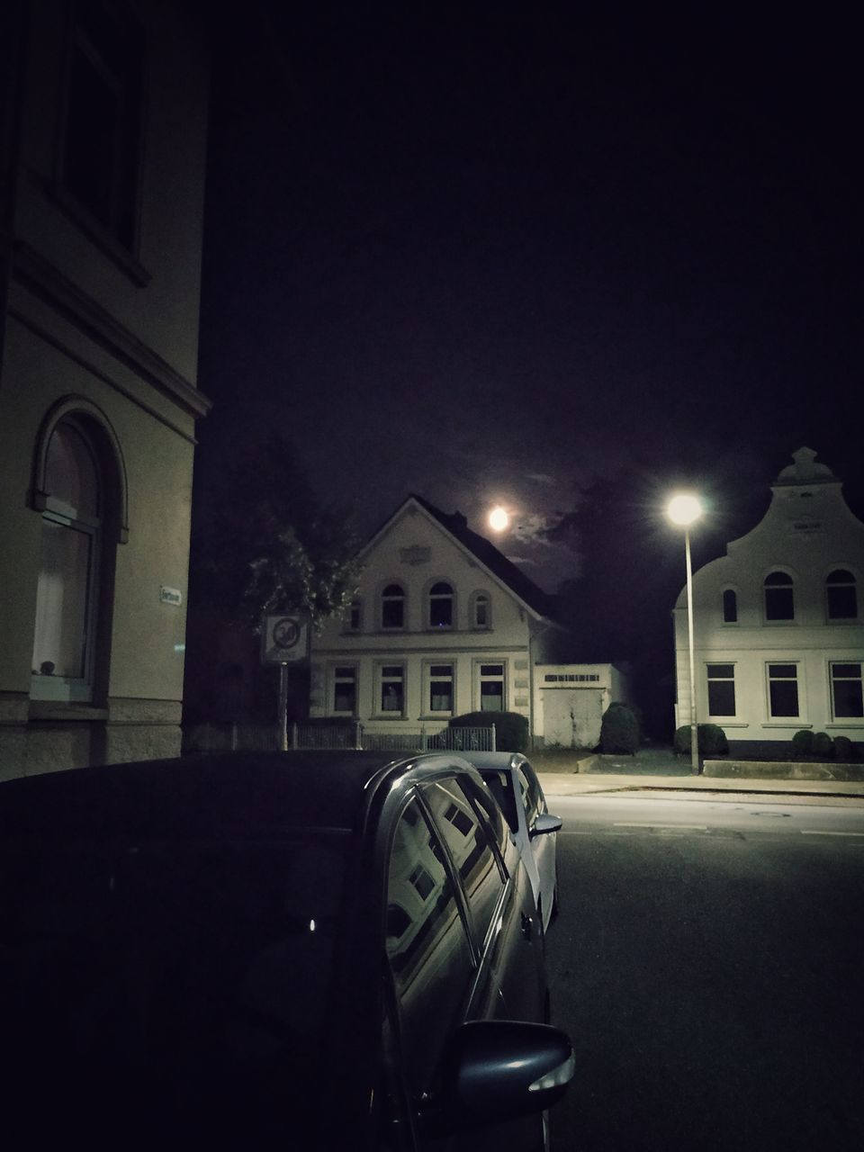 CARS ON STREET AGAINST ILLUMINATED BUILDINGS IN CITY