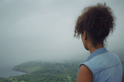 Rear view of woman looking at sea during foggy weather