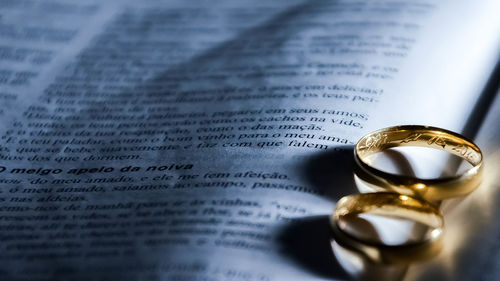 Close-up of gold wedding rings on open book