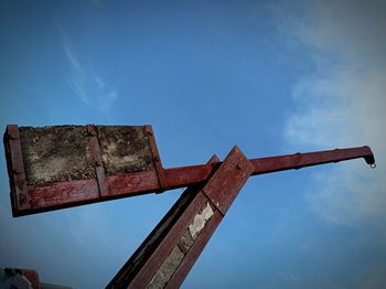 Low angle view of old cross against blue sky
