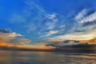 Scenic view of sea against dramatic sky during sunset