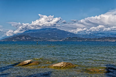 Scenic view of sea and snowcapped mountains against sky