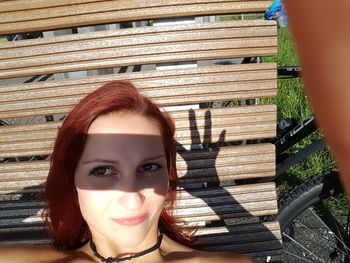 Portrait of woman smiling while sitting on bench