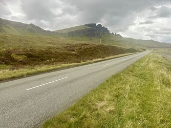 Road amidst field against sky