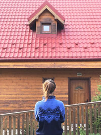 Rear view of woman standing against building