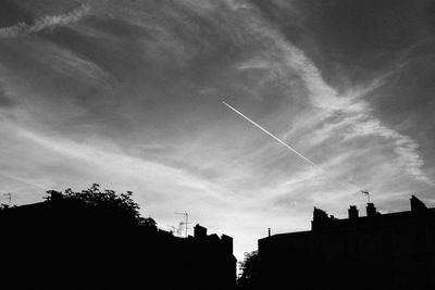 Low angle view of silhouette buildings against sky