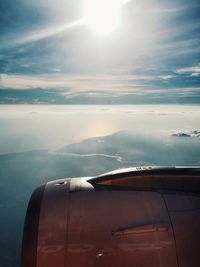 Airplane wing against sky during sunset