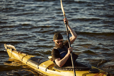 Man in yellow kayak holding oar