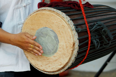 Midsection of man playing drum