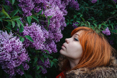 Close-up of woman smelling lilac flowers