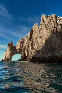 Rock formations in sea against blue sky