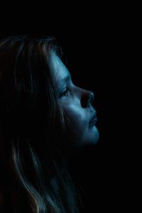 Close-up of sad girl in darkroom