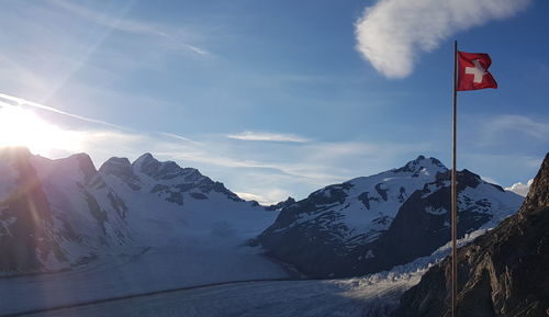 Scenic view of snowcapped mountains against sky during winter with the swiss flag and glacier