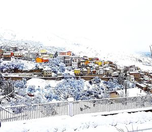 High angle view of houses over snow covered mountain