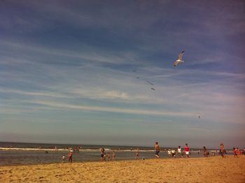 People at beach against sky