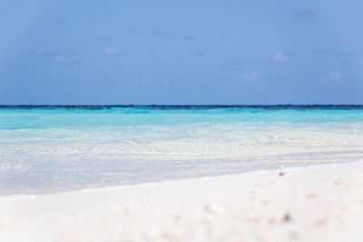 Scenic view of beach against blue sky