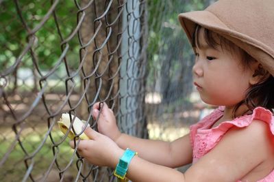 Midsection of woman looking through fence
