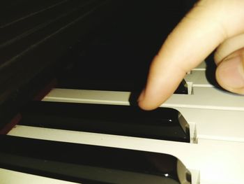 Close-up of hand holding piano