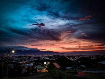 High angle shot of illuminated townscape against sky at sunset