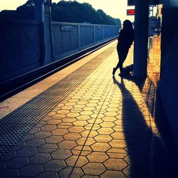 Rear view of silhouette woman walking on road