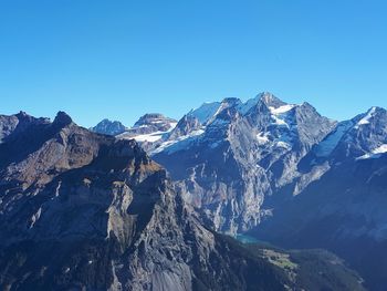 Scenic view of snowcapped mountains against clear blue sky