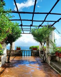 Narrow walkway in front of sea against sky